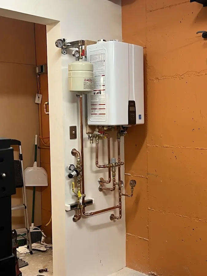 Plumbing technician inspecting water heater connections in New Orleans